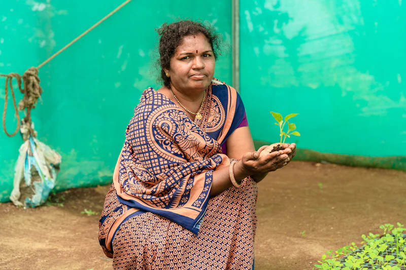 A volunteer holding a sapling at the Tree Plantation Drive